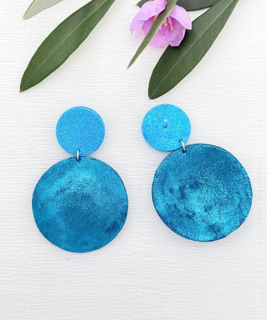 Wunderschöne Ohrringe aus feinem Leder mit einem runden Anhänger in einem schimmerndem Petrolton