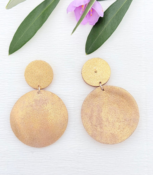 Zarte Ohrringe aus feinstem Leder mit einem runden Anhänger in edel schimmernden Goldtönen