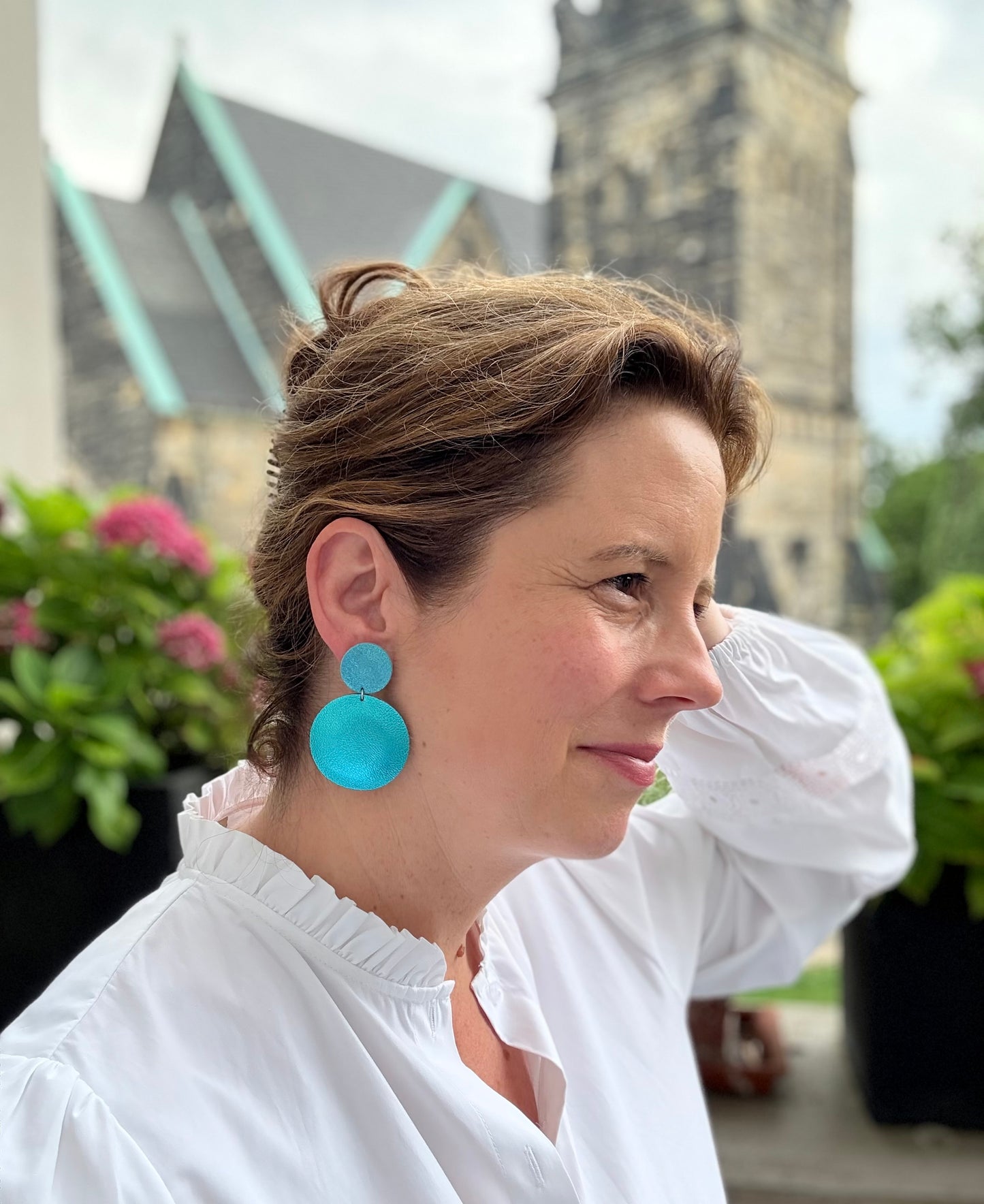 Edle Ohrringe aus feinem Leder mit einem runden Anhänger in Karibiktürkis