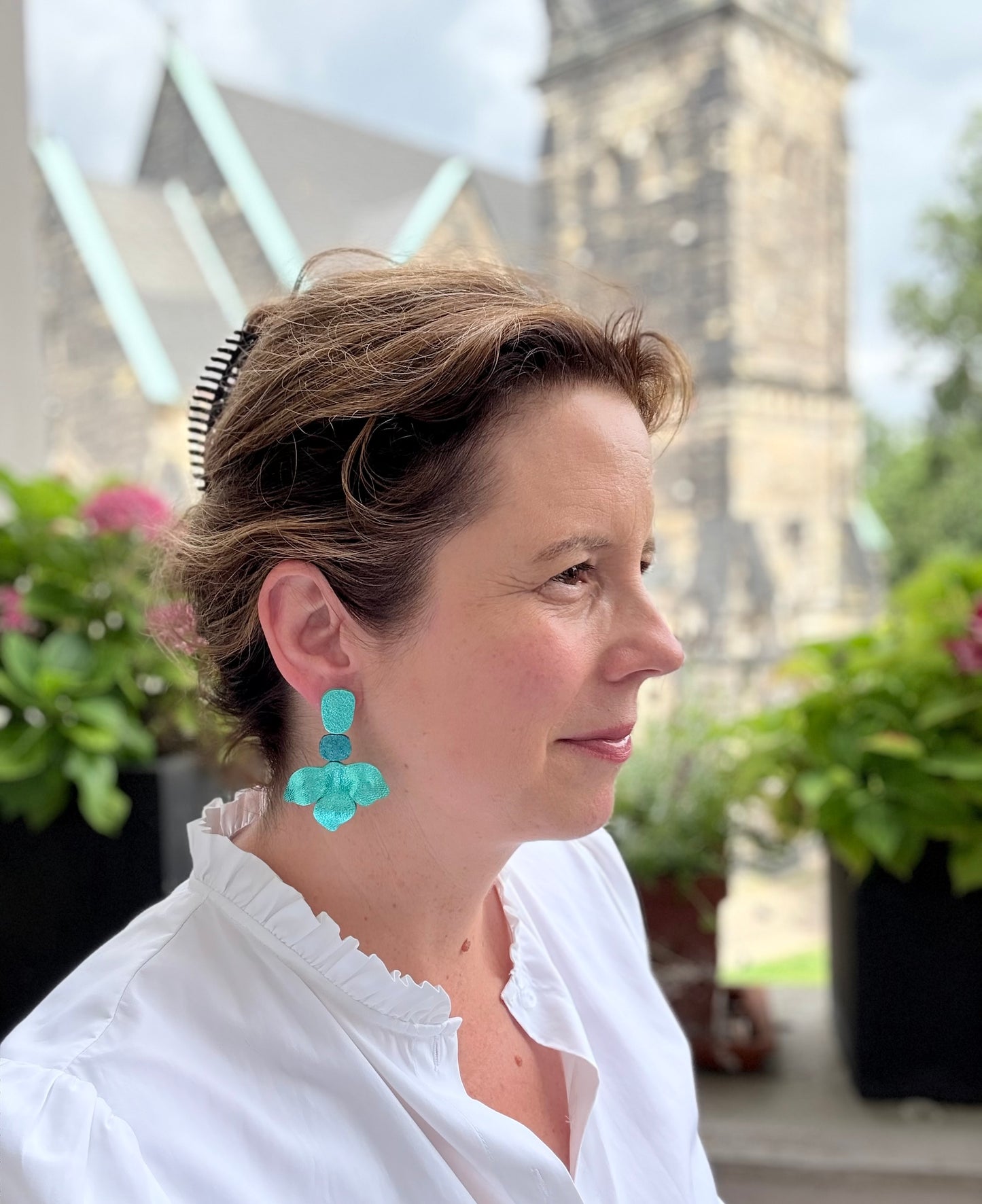 Traumhafte Ohrringe in Form einer türkisen Blüte aus schimmerndem feinen Leder