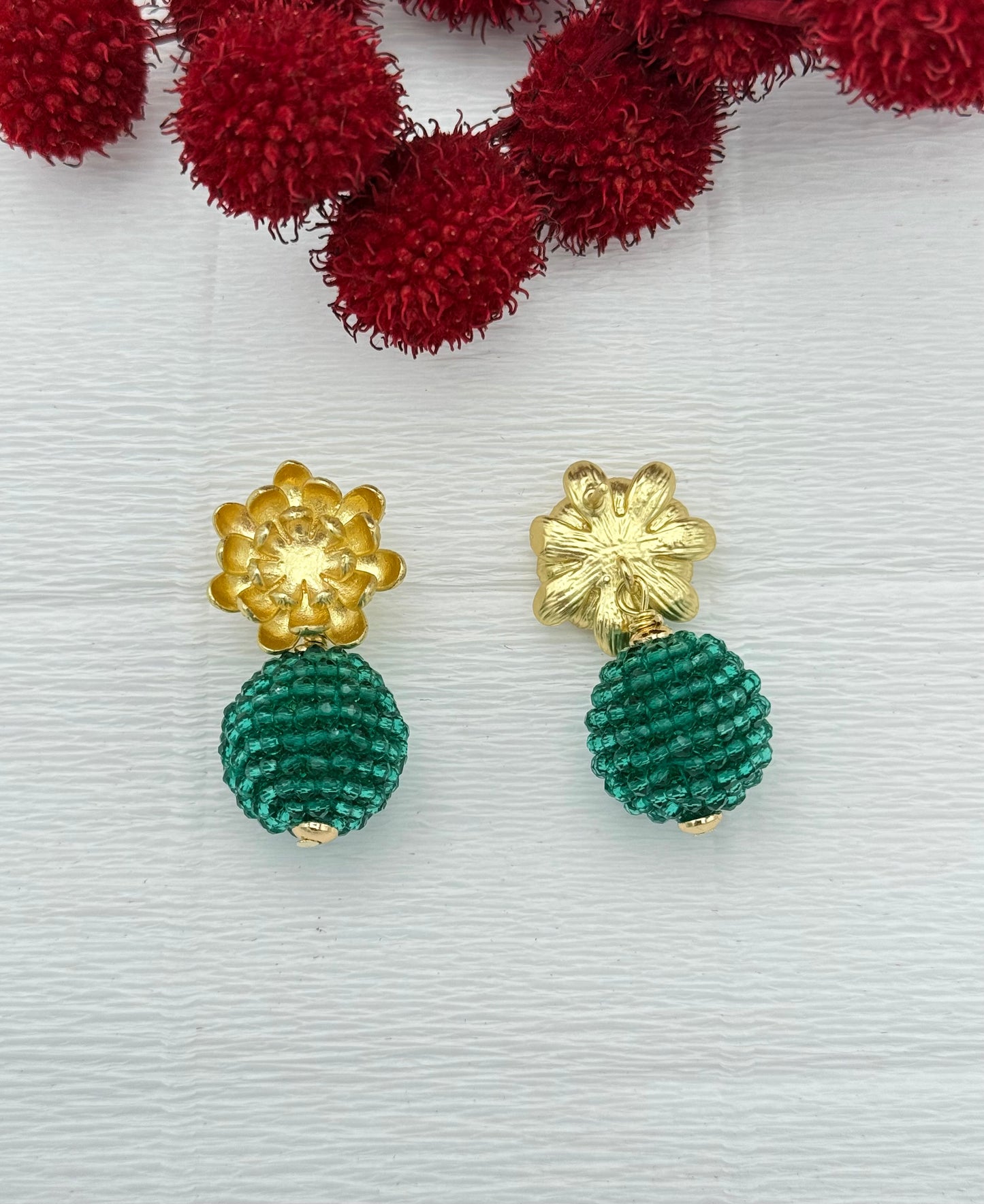 Goldene Blumenohrringe mit grüner Kristallkugel