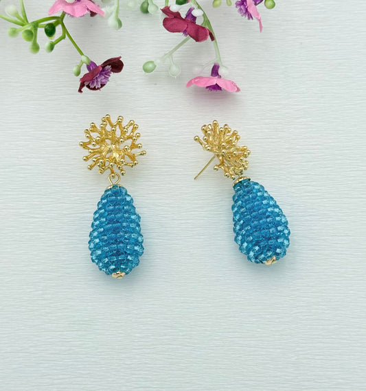 Schöne Ohrringe mit türkisem Glitzertropfen und Stecker in Korallenform
