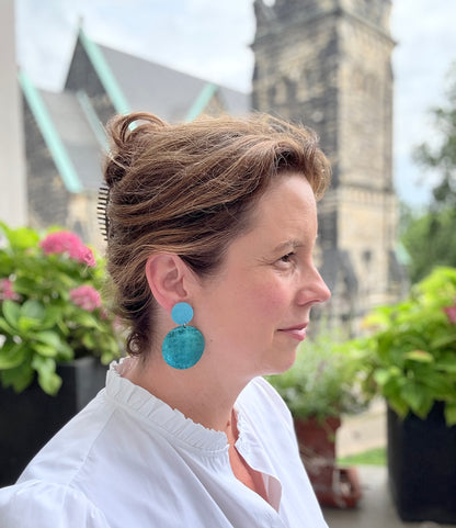 Wunderschöne Ohrringe aus feinem Leder mit einem runden Anhänger in einem schimmerndem Petrolton