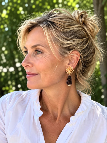 Goldene Korallstecker mit Glitzertropfen in glänzendem Braun