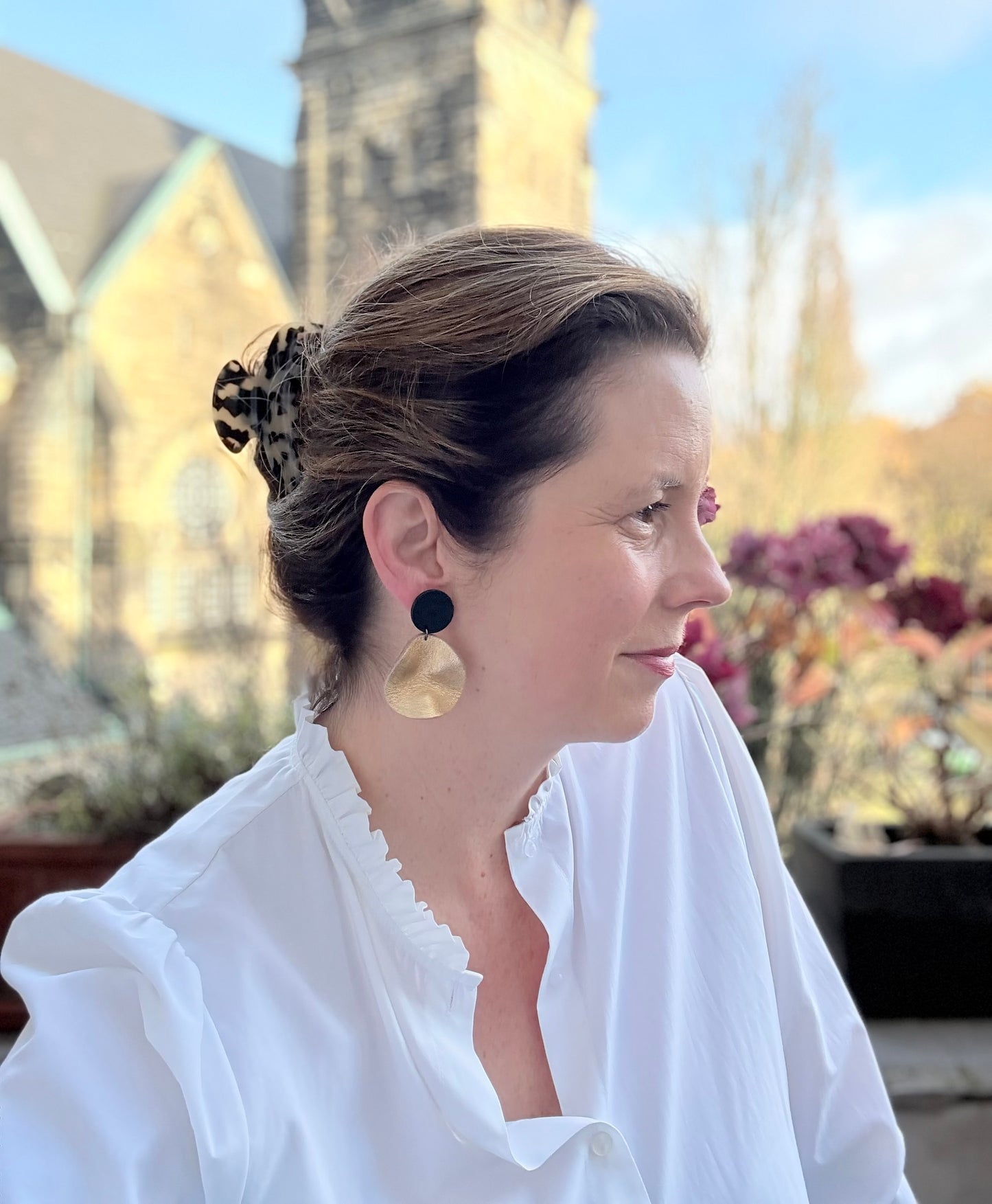 Goldene Ohrringe aus Leder mit einem kleinen gewellten Anhänger