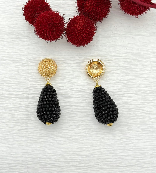 Goldene Ohrringe mit schwarzem Tropfen