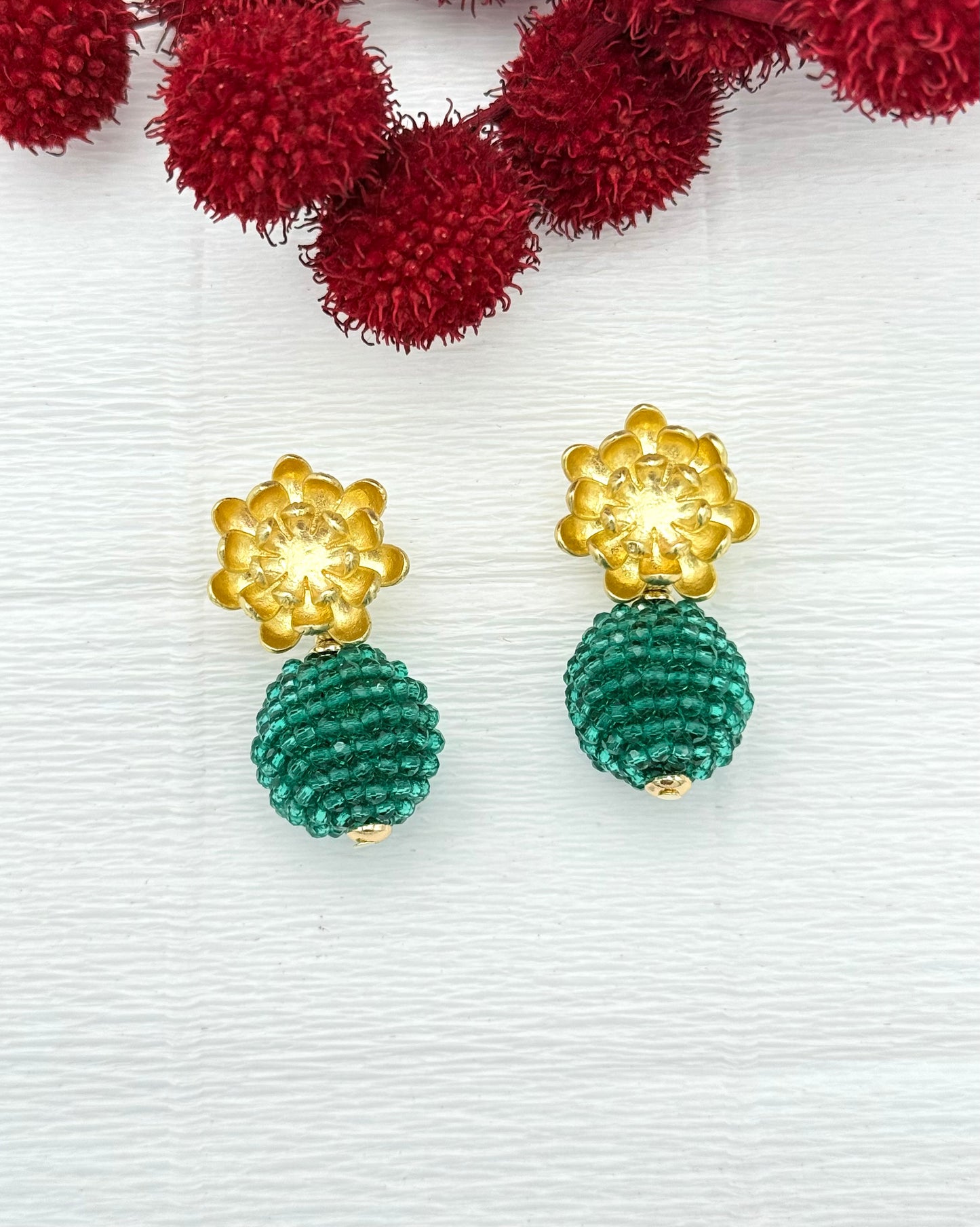 Goldene Blumenohrringe mit grüner Kristallkugel
