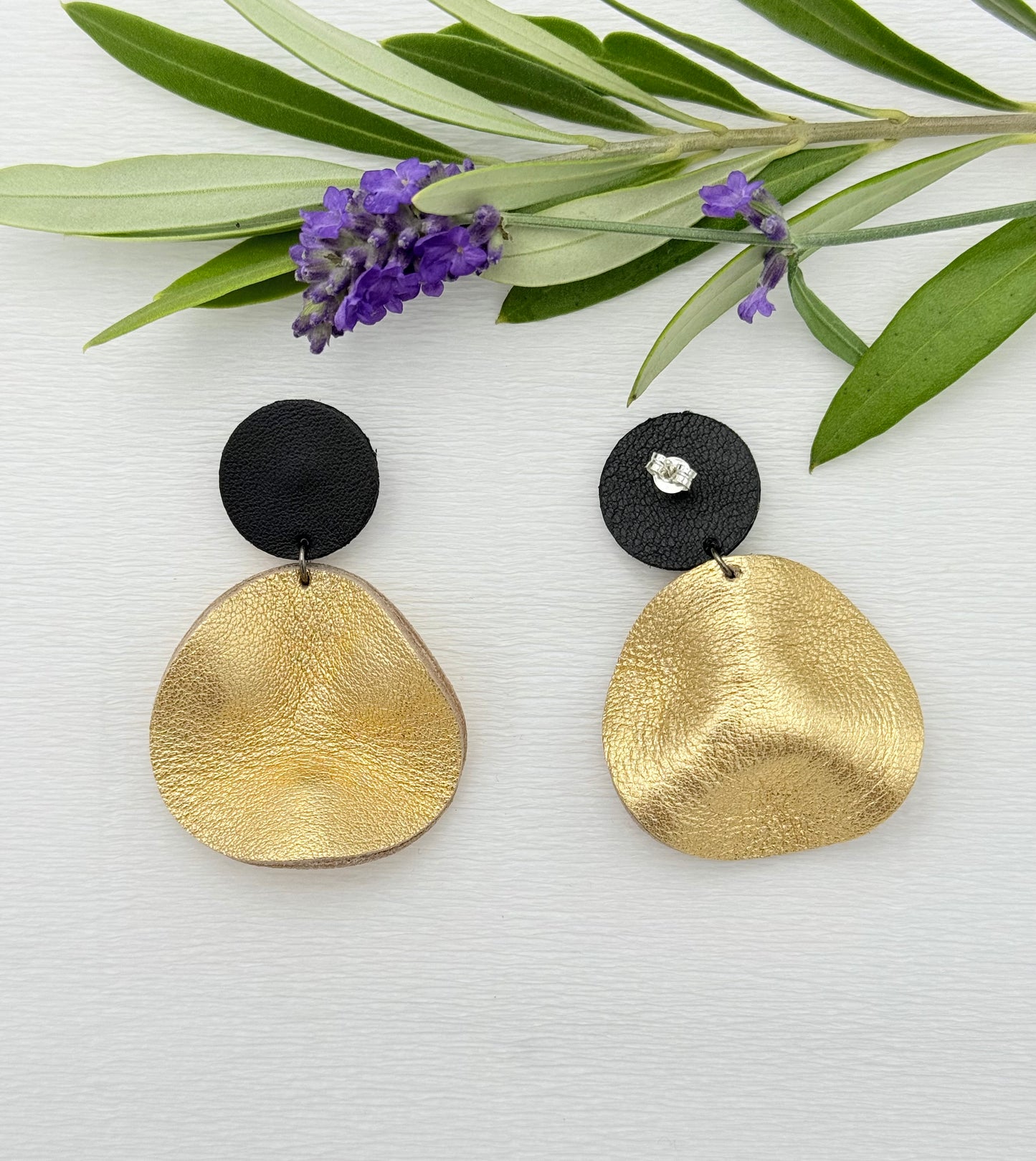 Goldene Ohrringe aus Leder mit einem kleinen gewellten Anhänger